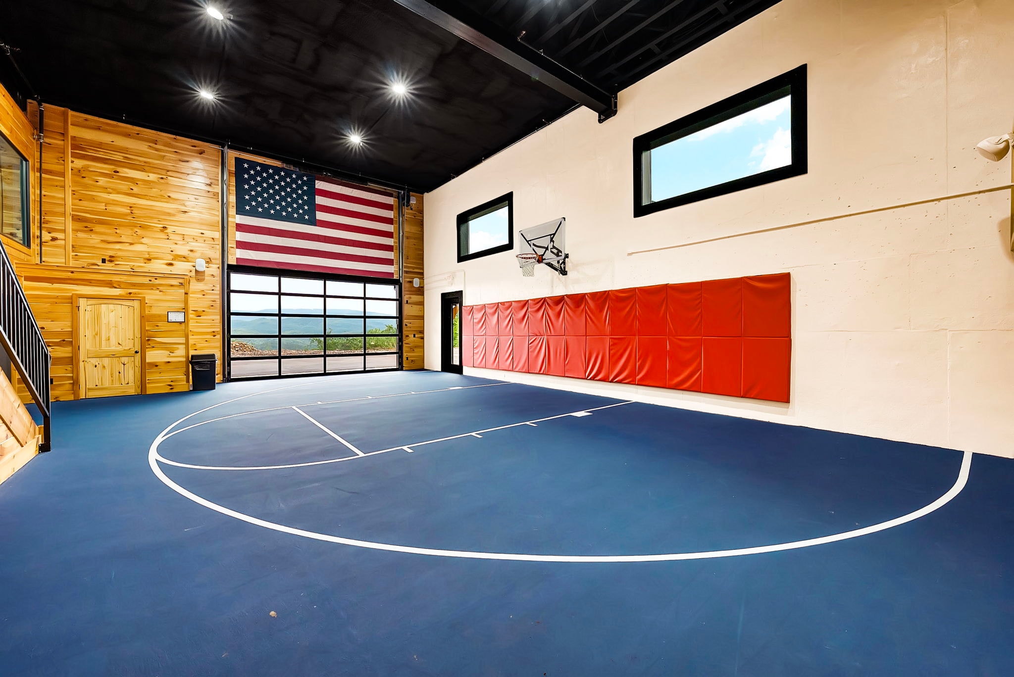Excalibur private indoor basketball court with American flag, luxury lodge