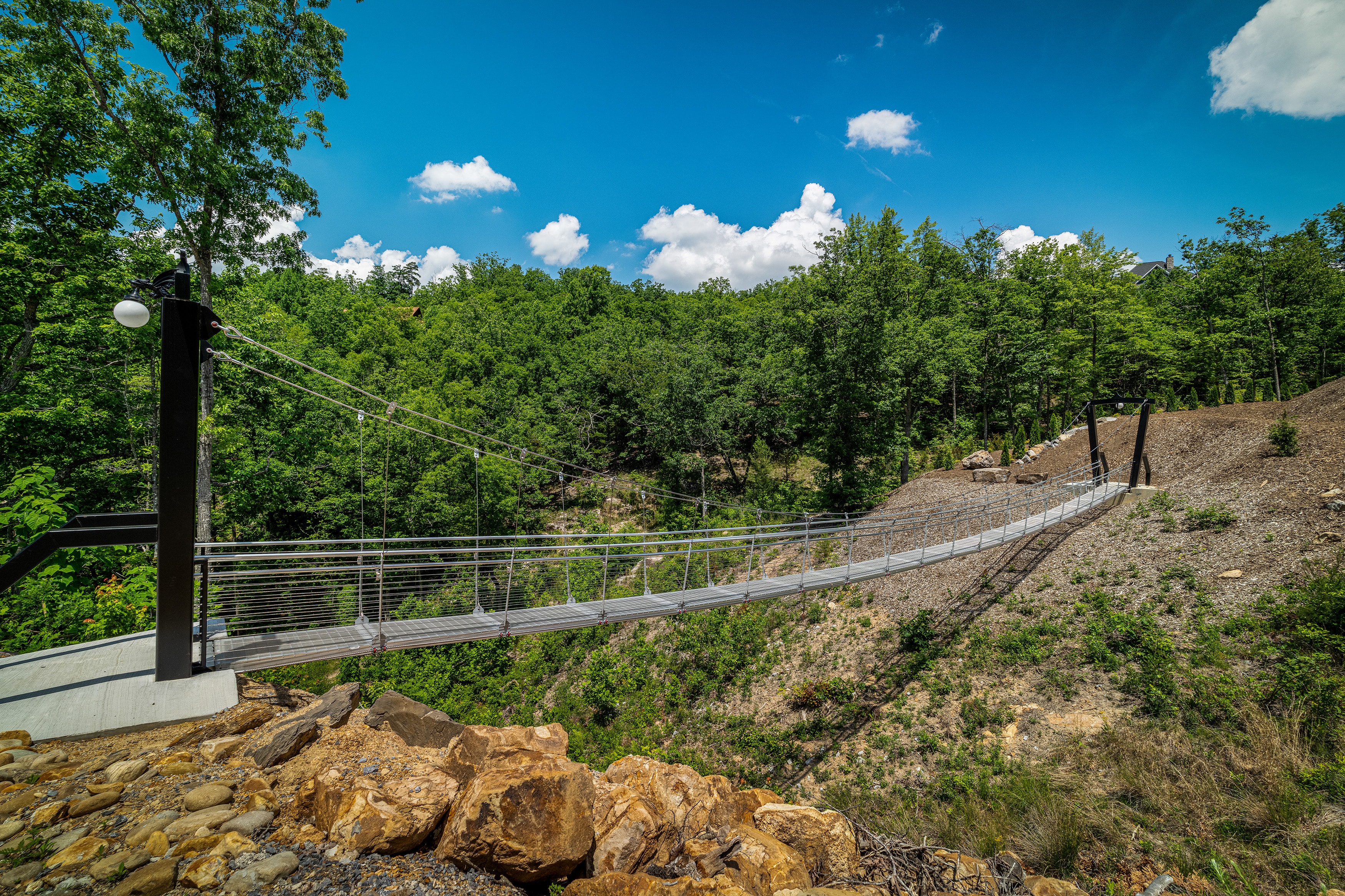 Guests crossing Excalibur's private 100-foot swinging skybridge on Bluff Mountain