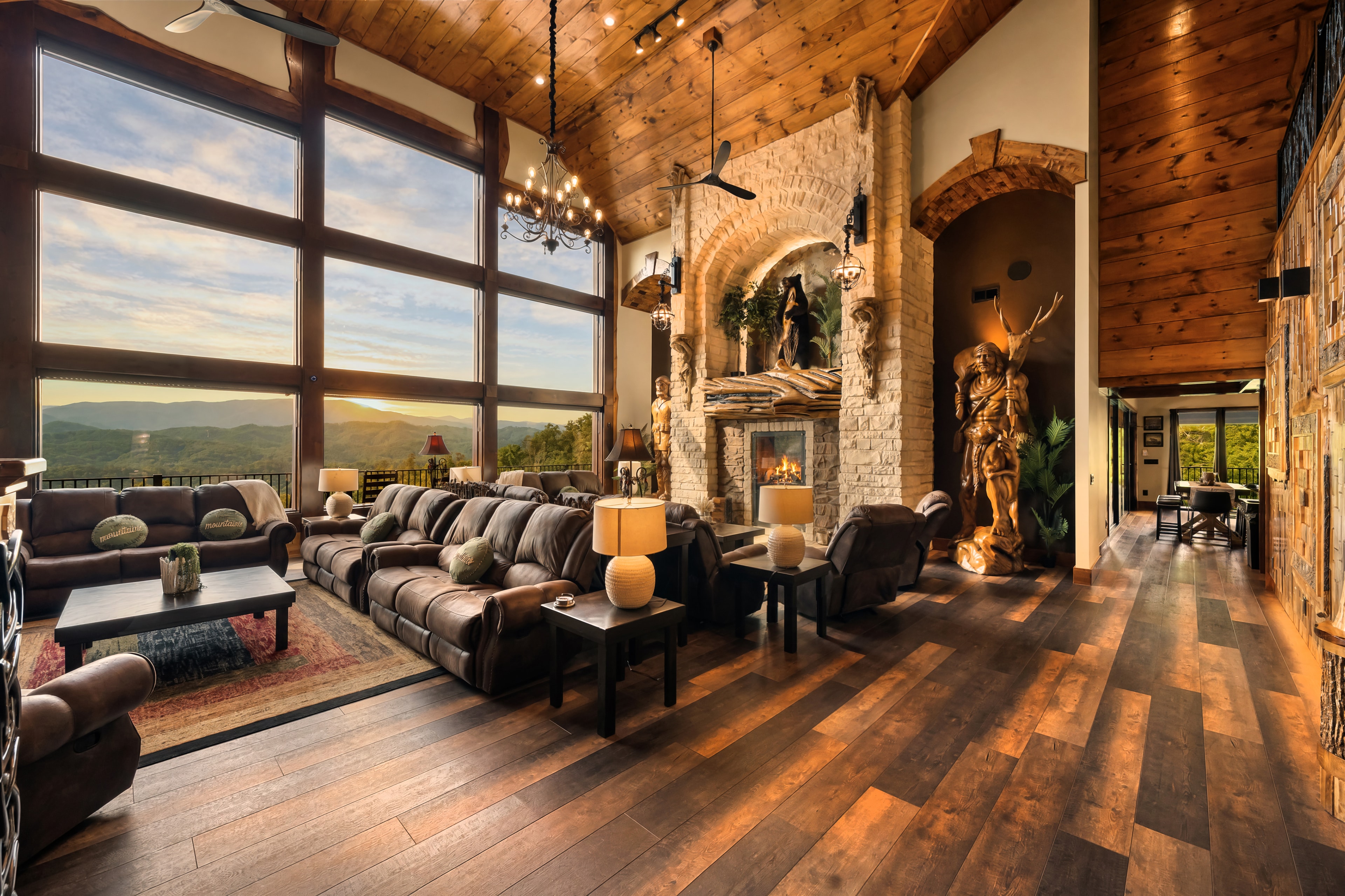 Excalibur great room floor-to-ceiling windows panoramic Smoky Mountain view stone fireplace leather seating