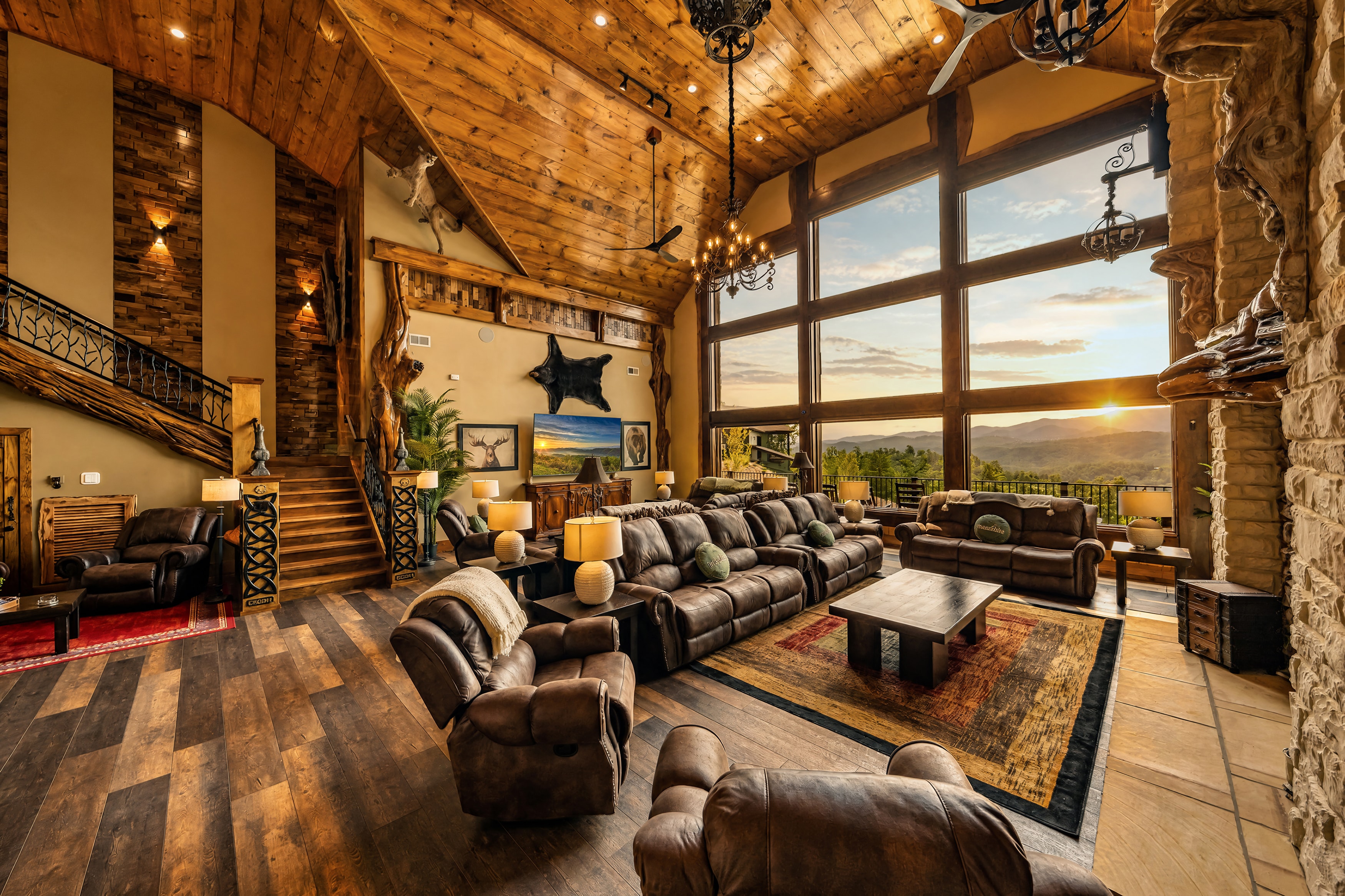 Excalibur great room with leather seating, floor-to-ceiling mountain view windows, and soaring cathedral ceiling