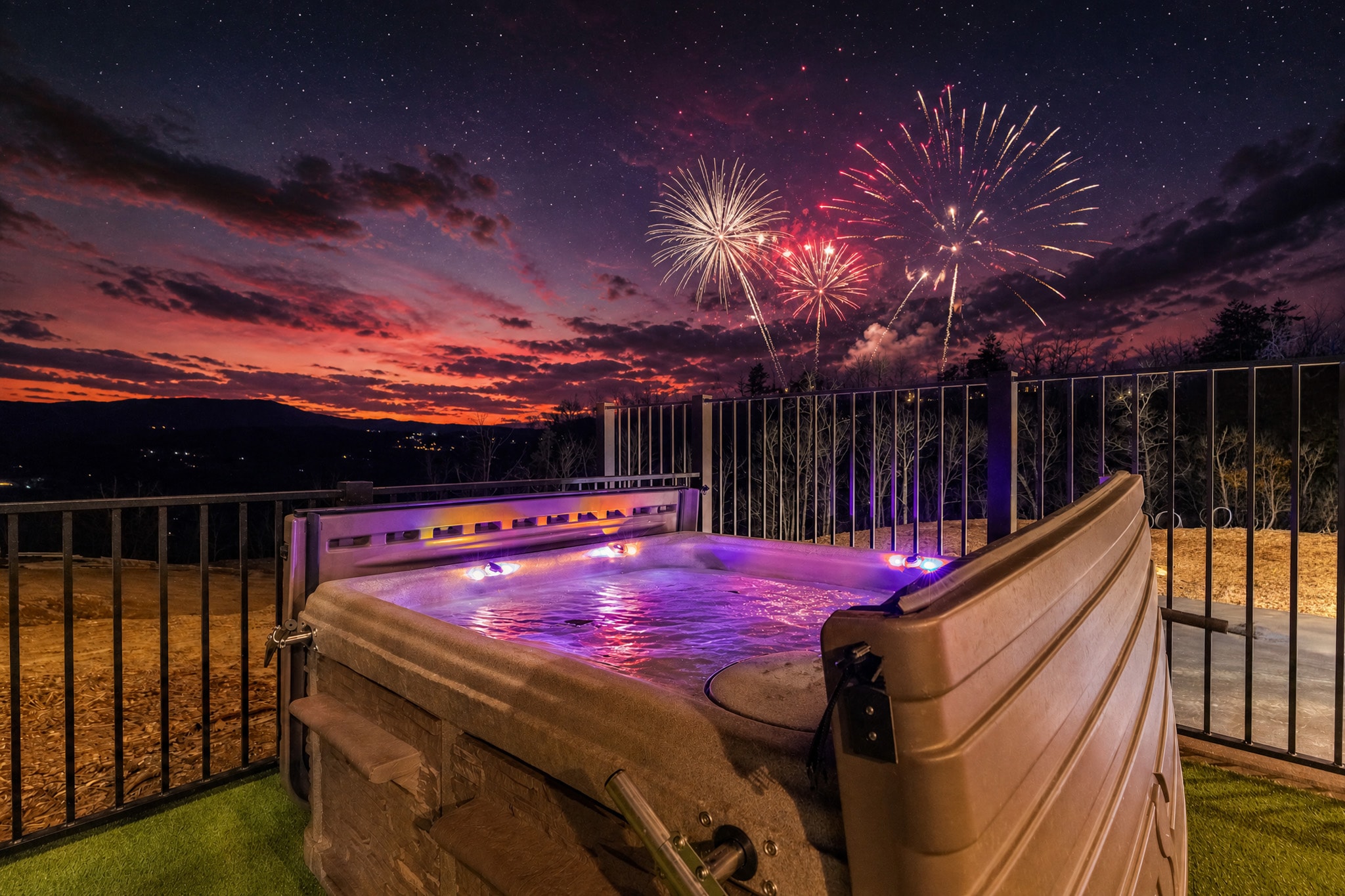 Excalibur illuminated hot tub fireworks bursting over Smoky Mountains July 4th luxury lodge